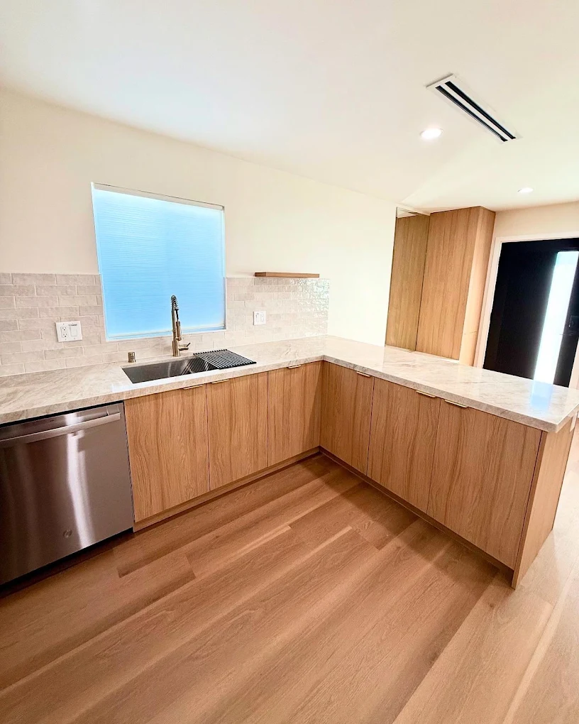 U-shaped kitchen with quartz counters & tile backsplash