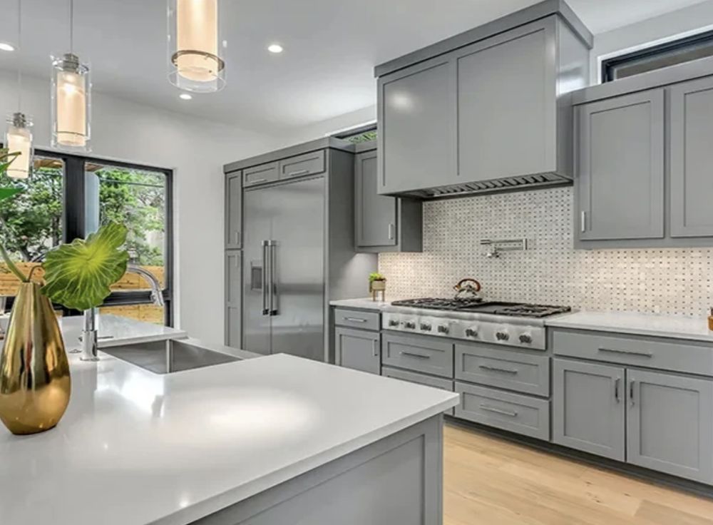 Gray shaker kitchen with quartz island & pro range